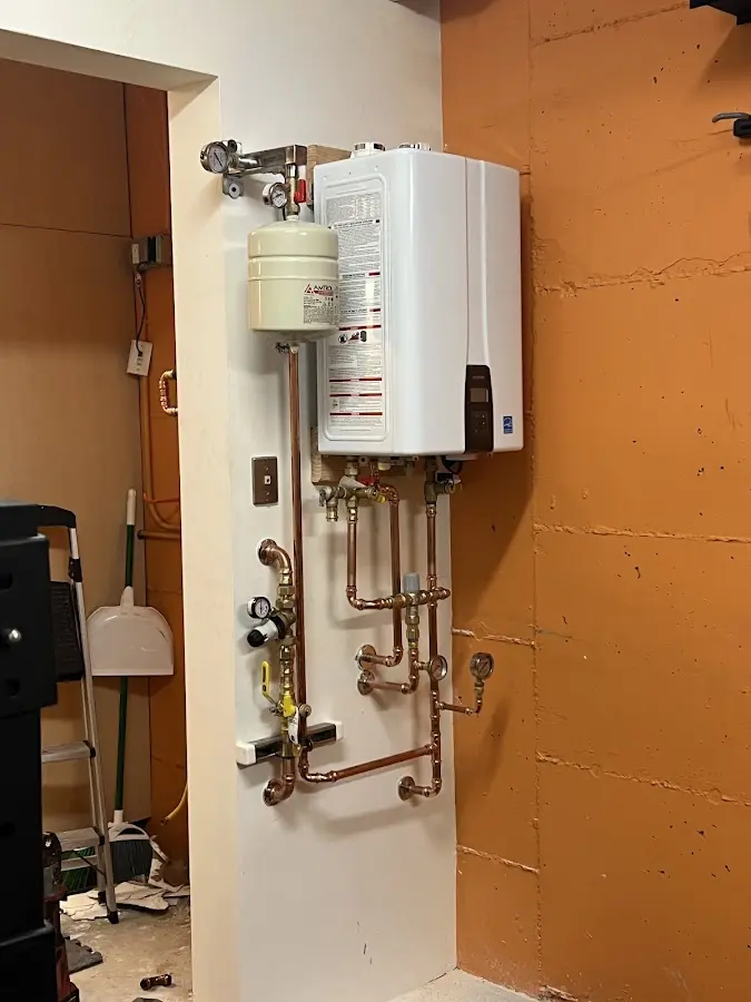 Plumbing technician inspecting water heater connections in Discovery Bay